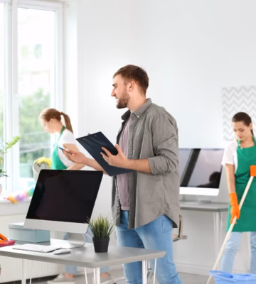 Employees are performing cleaning tasks while a workplace inspection is underway.