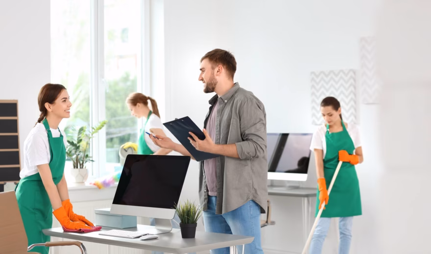 Employees are performing cleaning tasks while a workplace inspection is underway.