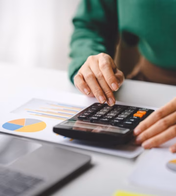 Een medewerker berekent en controleert financiële gegevens aan de hand van rapportages en grafieken.