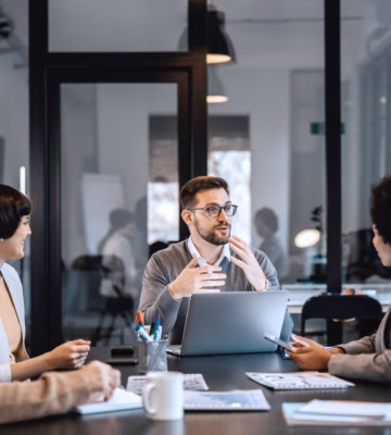 Mitarbeiter besprechen während einer Besprechung im Büro Abläufe und die Zusammenarbeit.