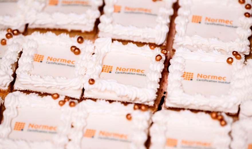 Cakes with a logo are presented during a gathering or celebration within the organization.