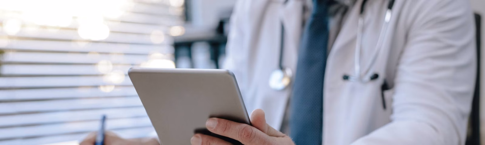Ein medizinischer Fachangestellter ruft Daten über ein Tablet in einer medizinischen Einrichtung ab und verarbeitet sie.