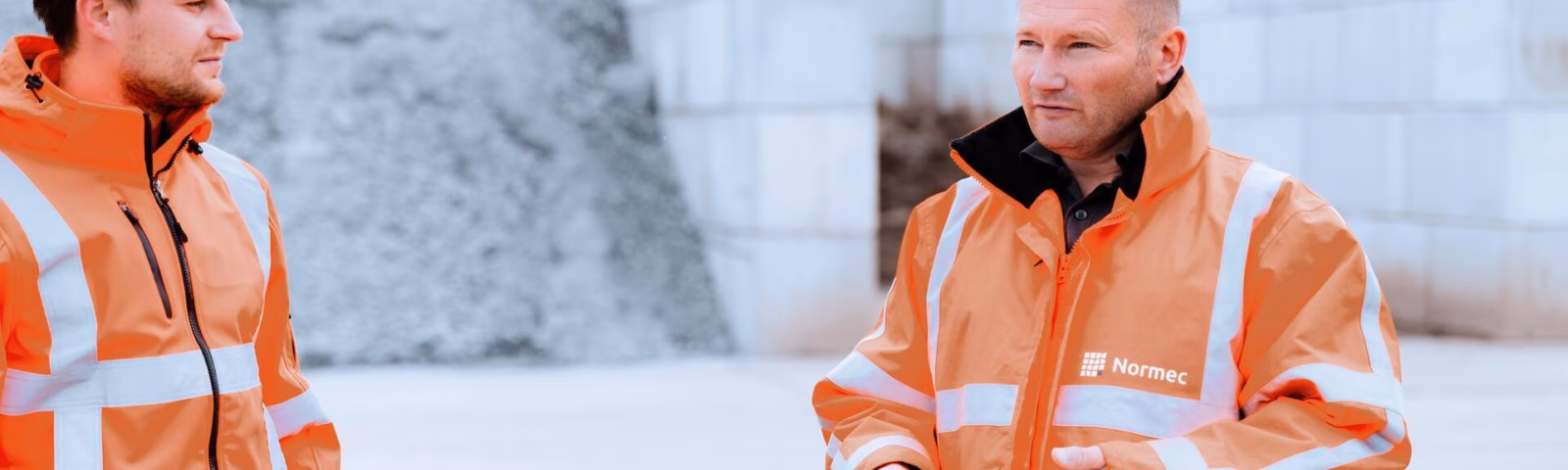 Two employees are holding a meeting at an industrial site during an inspection or check.