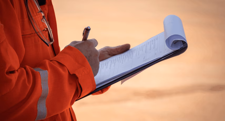 An employee records findings during an on-site inspection or check.