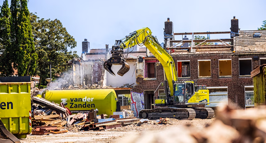 Ein elektrischer Bagger führt Abbrucharbeiten auf einer Bau- und Sanierungsbaustelle durch.