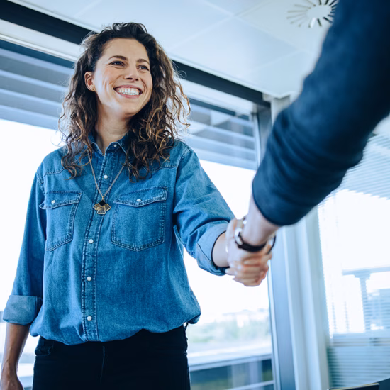 Two professionals greet each other during a business meeting at the office.