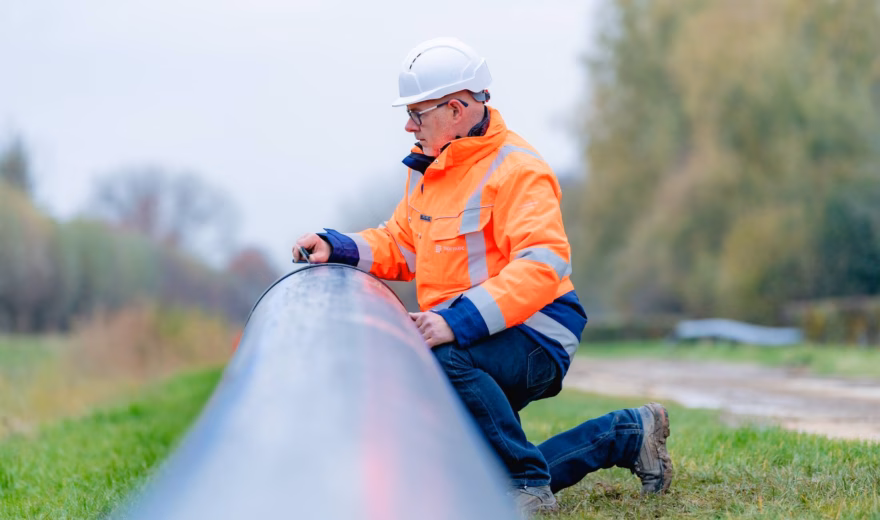 A pipe is being checked during an inspection in an outdoor setting.
