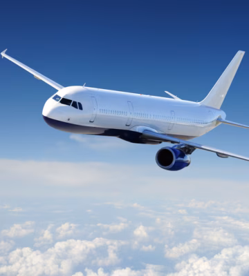 A passenger plane is flying at cruising altitude above a layer of clouds.