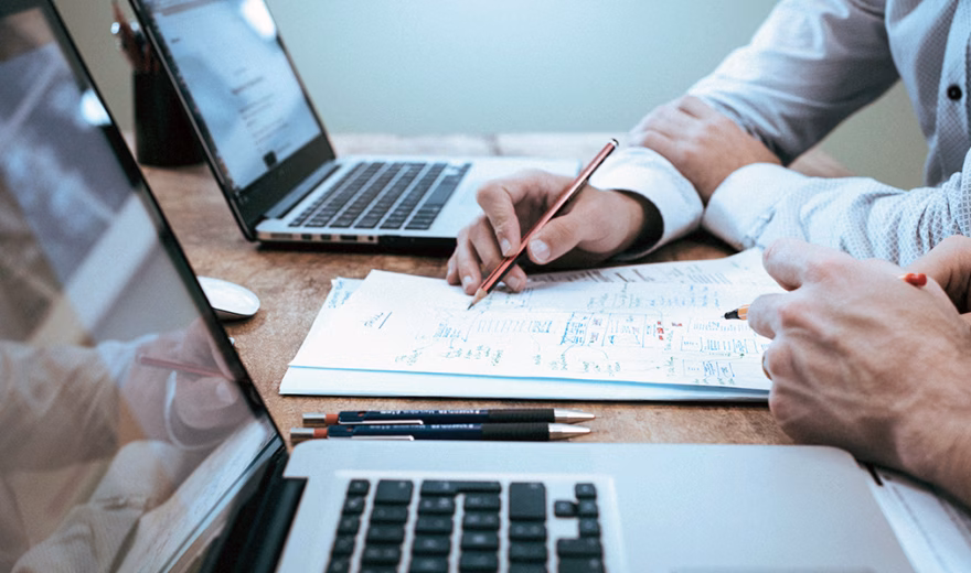 Documents and notes are discussed together during a meeting at the office.
