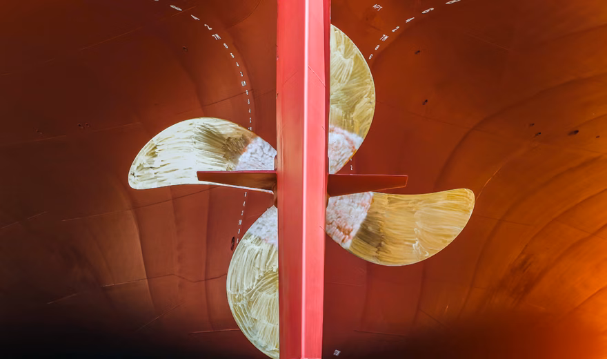 A ship's propeller is visible in a dry dock where inspection and maintenance work is being carried out.