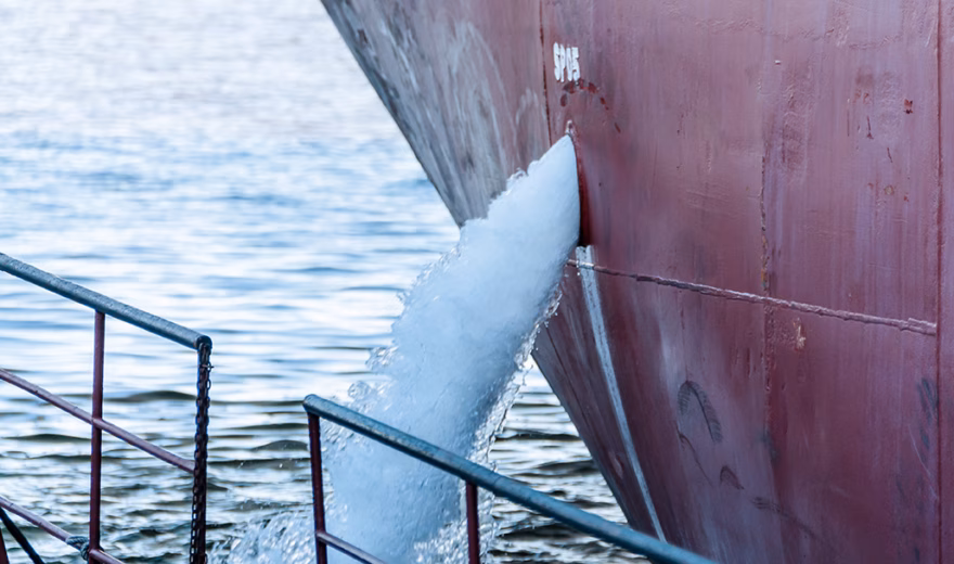 Während der Arbeiten an Bord fließt Wasser aus einer Öffnung im Schiff ins Meer.
