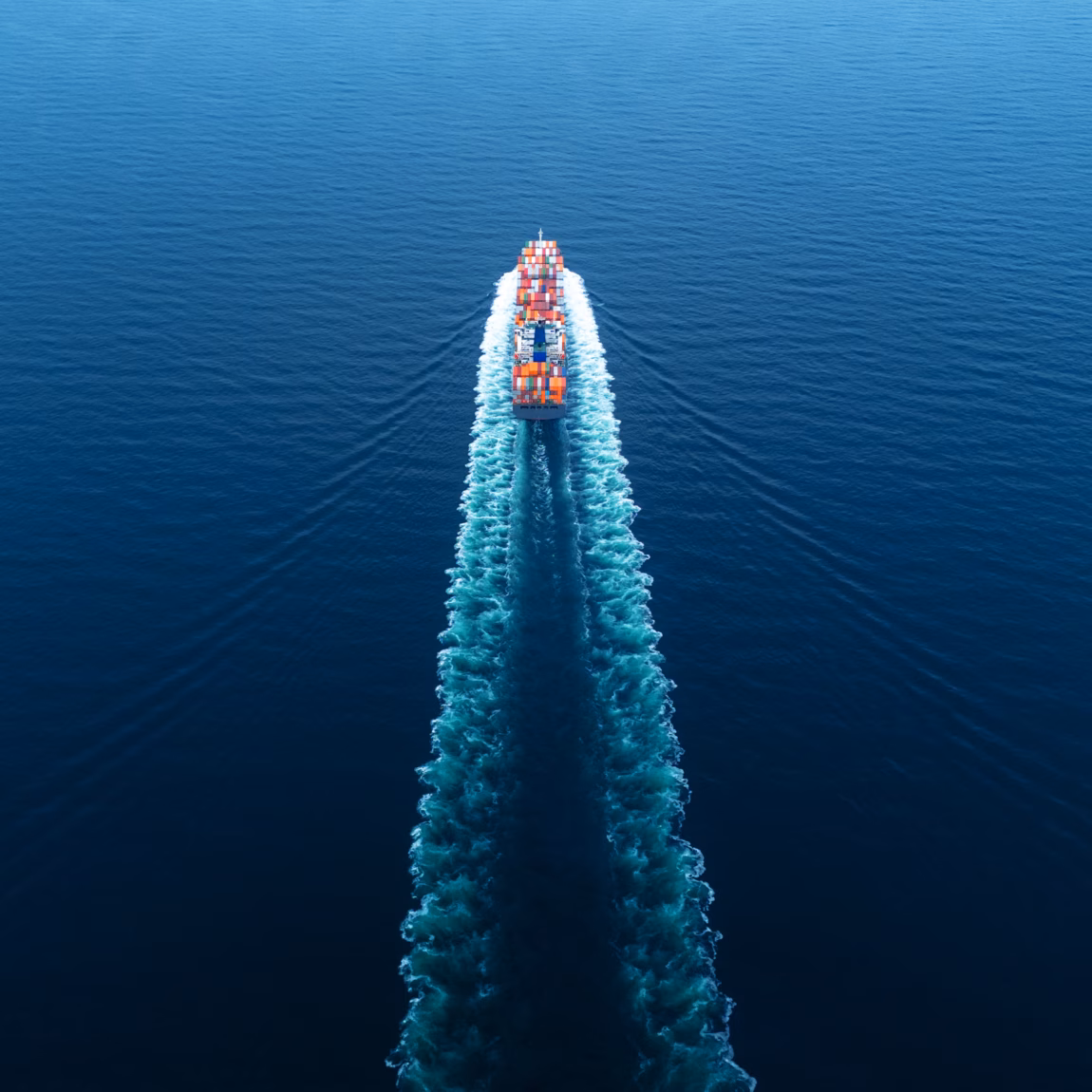 Ein Containerschiff transportiert Frachtcontainer auf offener See im Rahmen des internationalen Güterverkehrs.