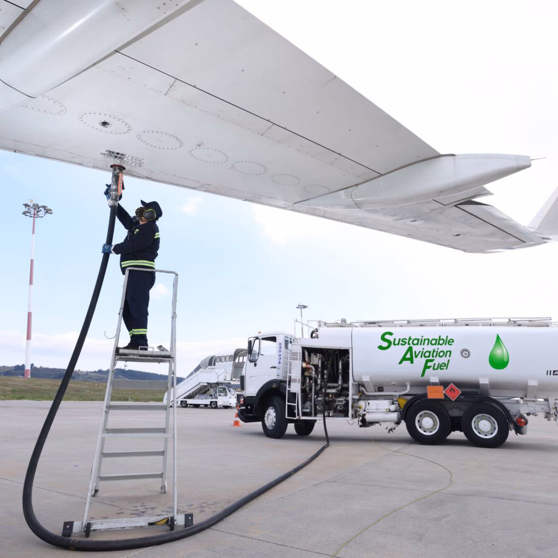 Ein Flugzeug wird auf dem Vorfeld des Flughafens mit nachhaltigem Flugkraftstoff betankt.