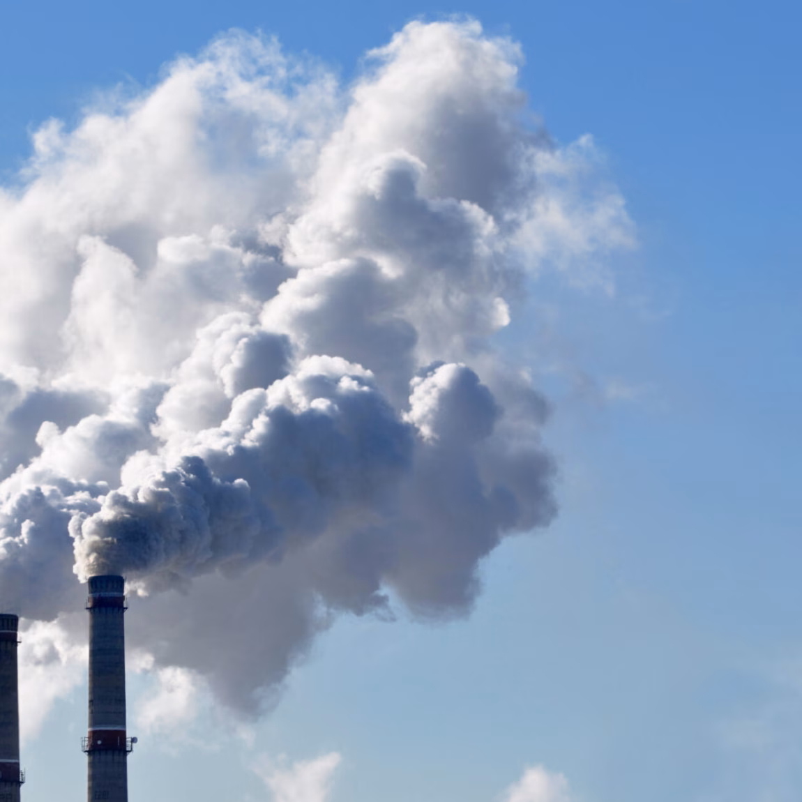 Industrial emissions rise from smokestacks as part of a production or energy process.
