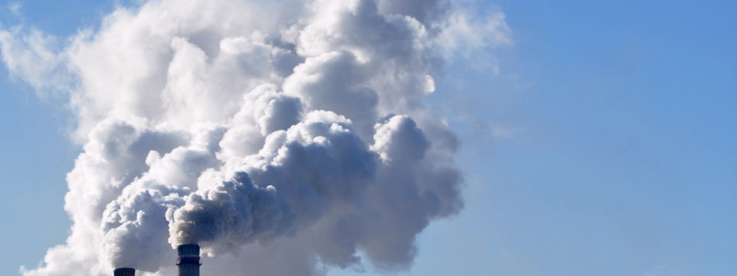 Industrial emissions rise from smokestacks as part of a production or energy process.