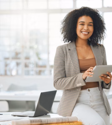 A professional works with a tablet in a modern office environment for digital collaboration and data management.