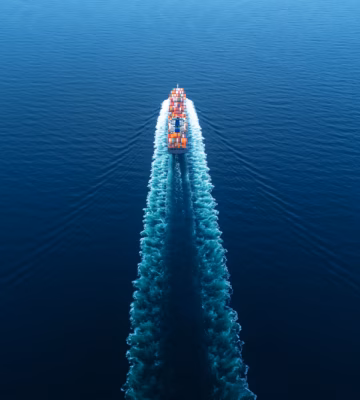 A container ship transports cargo containers across the open sea for international freight transport.