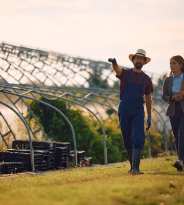 Two people are discussing work activities and cultivation processes at a greenhouse horticulture operation.