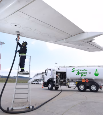 An airplane is being refueled with sustainable aviation fuel on the airport tarmac.