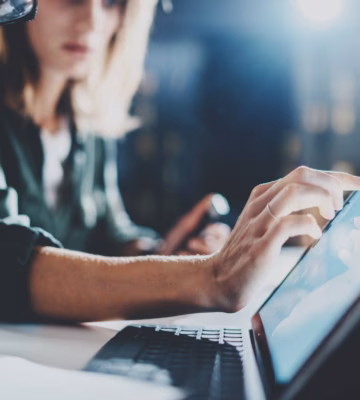 Employees analyze data and collaborate on digital processes using a laptop.
