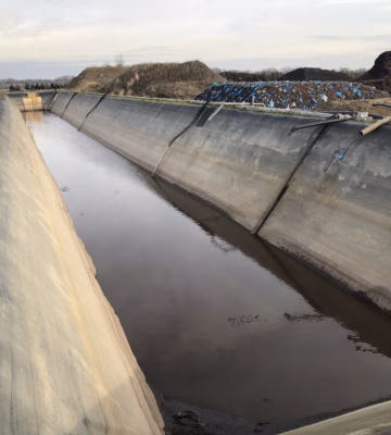Een waterbassin met afdichtingsconstructie voor de opvang en beheersing van vloeistoffen op een industriële locatie.