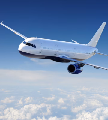 A passenger plane is flying at cruising altitude above a layer of clouds.