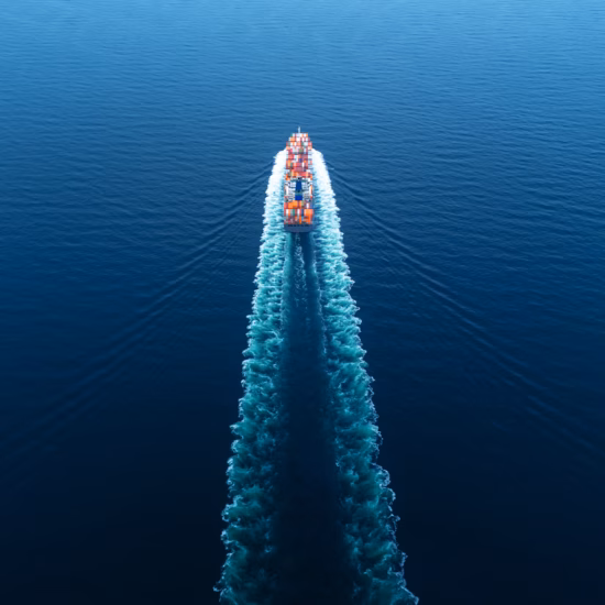 A container ship transports cargo containers across the open sea for international freight transport.