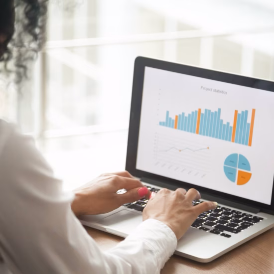 An employee reviews data and statistics using a digital dashboard for analysis and reporting.