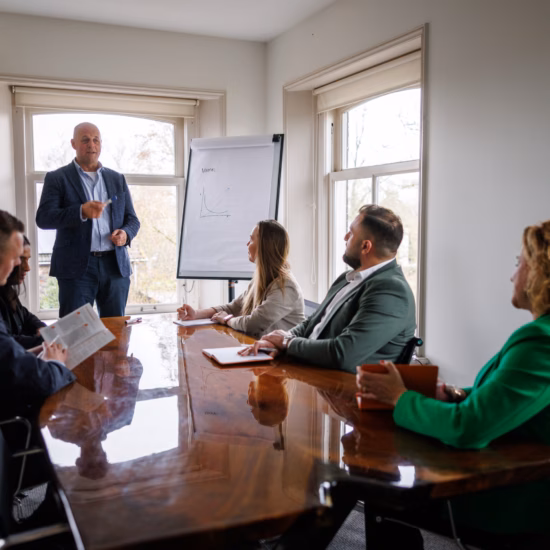 A professional gives a presentation to colleagues during a team meeting in a conference room.