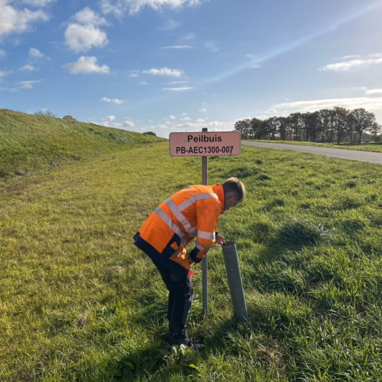 An employee is checking a monitoring well as part of on-site groundwater monitoring.