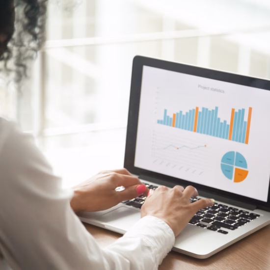 Ein Experte analysiert Daten auf einem Laptop, wobei Diagramme und Dashboards auf dem Bildschirm angezeigt werden.