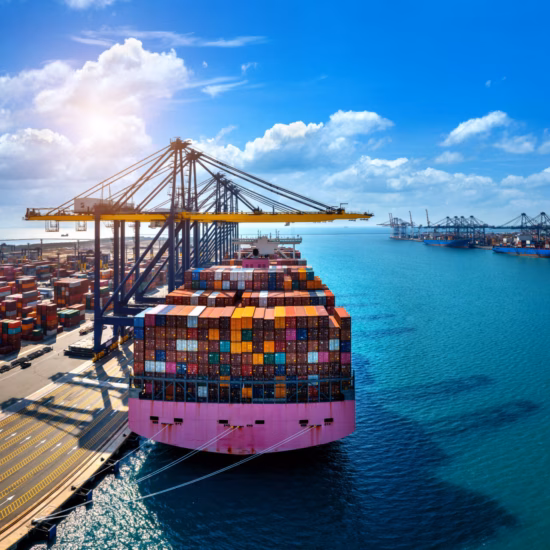 A container ship is being loaded and unloaded at a container terminal for international freight transport.