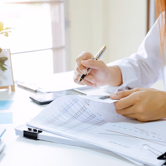 Een persoon beoordeelt documenten en gegevens tijdens een administratieve controle.