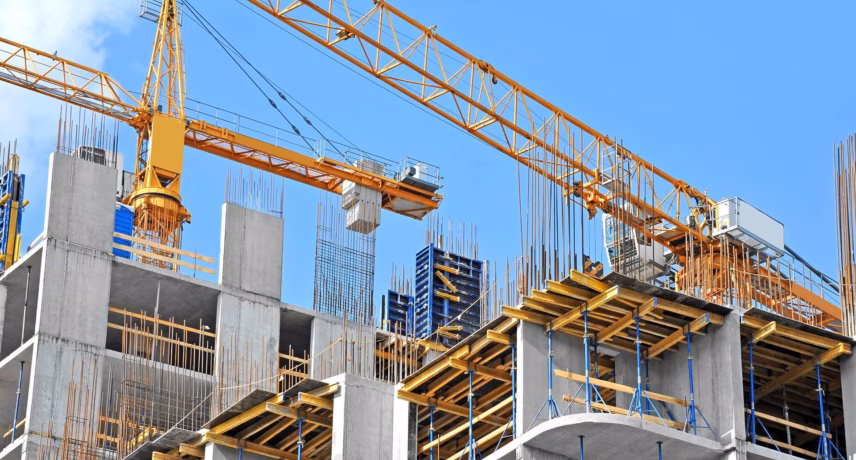 A construction site featuring a building under construction and multiple cranes. The image relates to themes such as construction safety, quality management, certification, and sustainable project management in the construction industry.