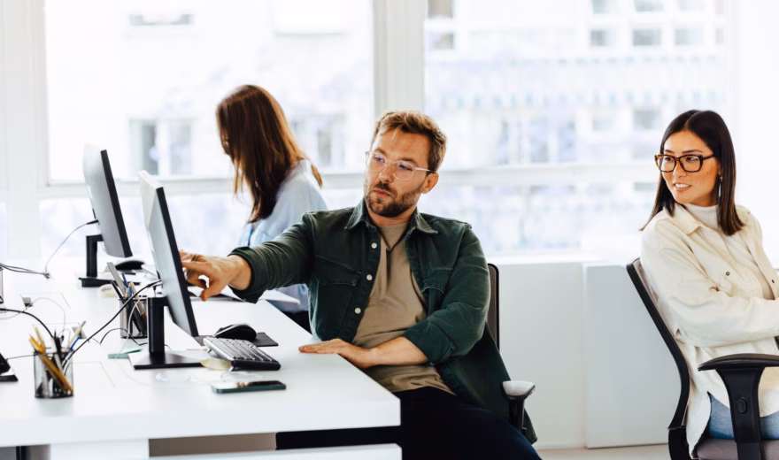 Employees discuss information and collaborate on tasks in a modern office environment.