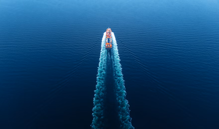 Ein Containerschiff transportiert Frachtcontainer auf offener See im Rahmen des internationalen Güterverkehrs.
