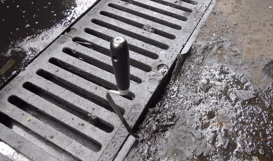A drainage channel is being inspected as part of inspection and maintenance work at an industrial site.