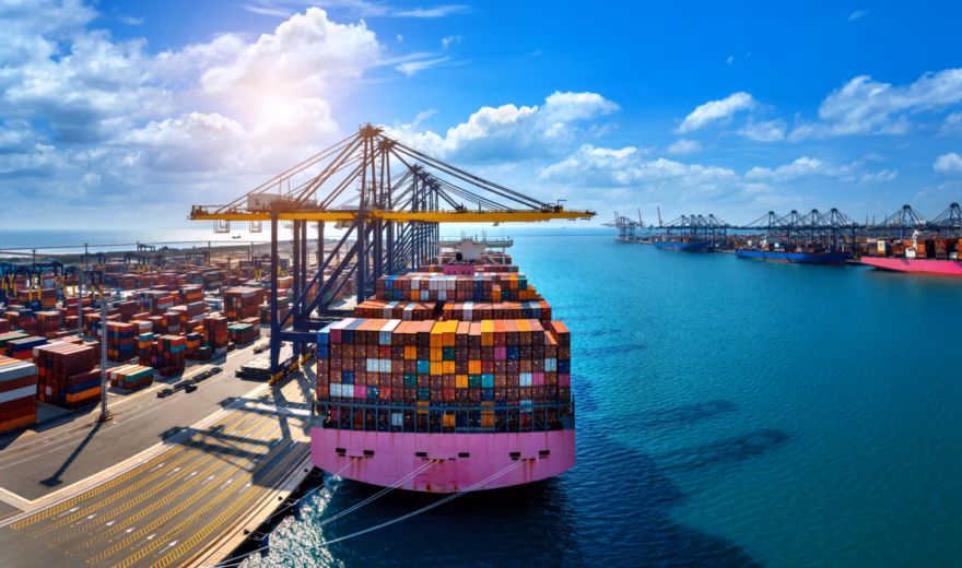 A container ship is being loaded and unloaded at a container terminal for international freight transport.