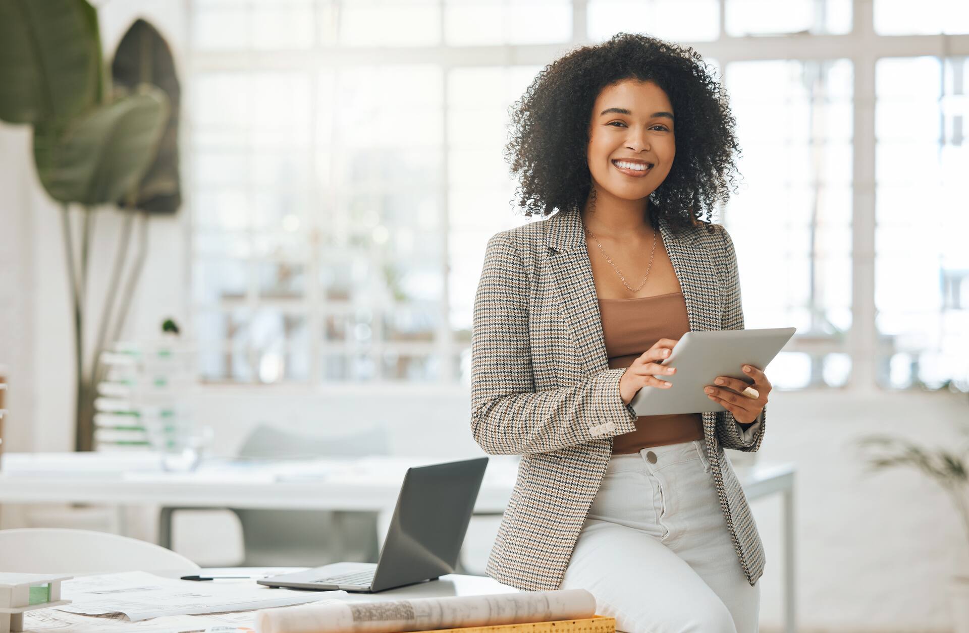 A professional works with a tablet in a modern office environment for digital collaboration and data management.
