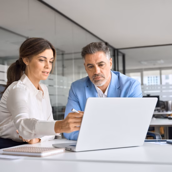 Two professionals are discussing data and documentation during a meeting at the office.