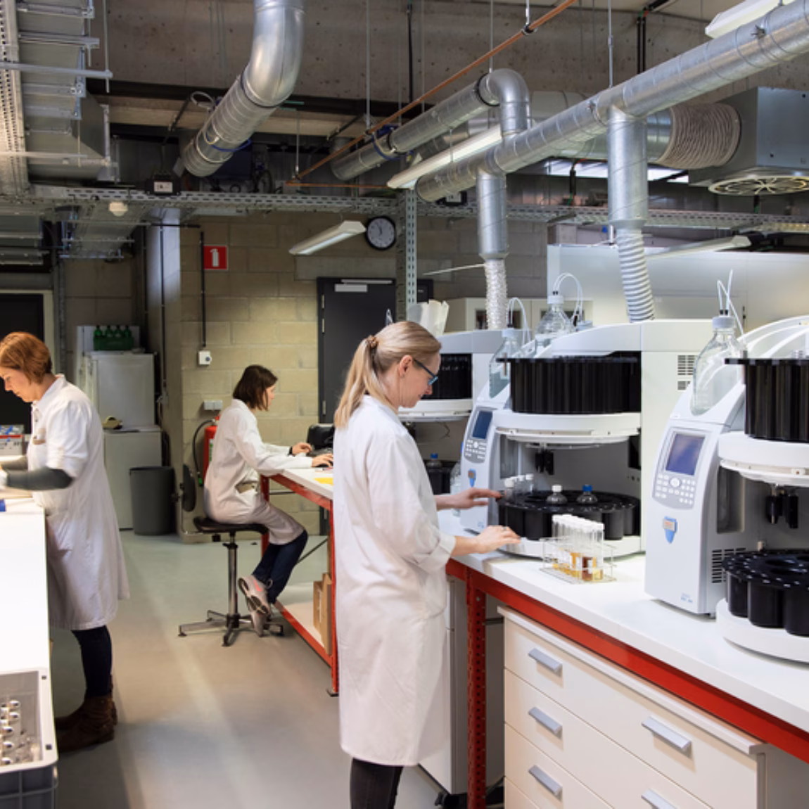 A modern laboratory equipped with automated analytical instruments and staff who perform laboratory tests.