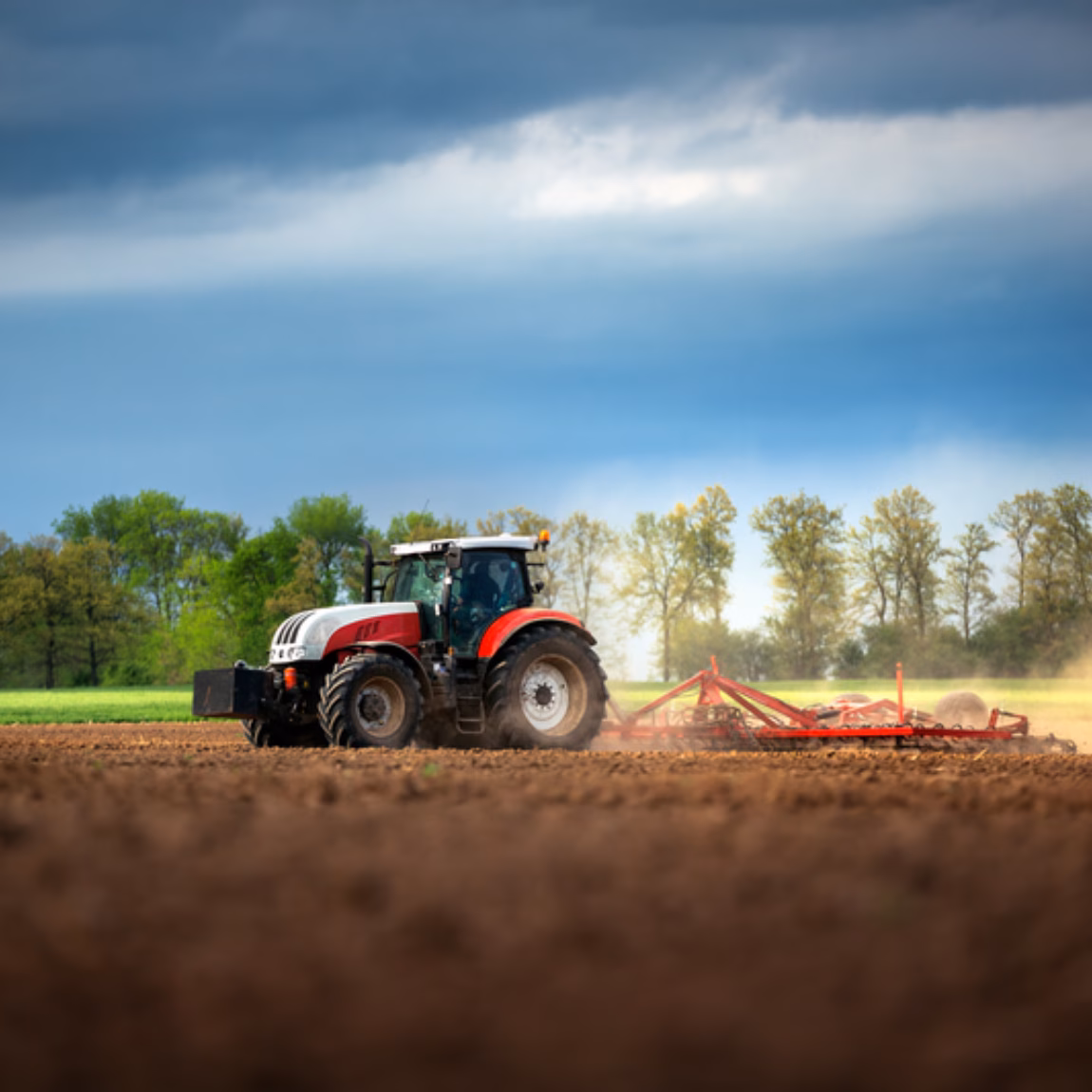 A tractor is tilling farmland in a field during outdoor fieldwork.