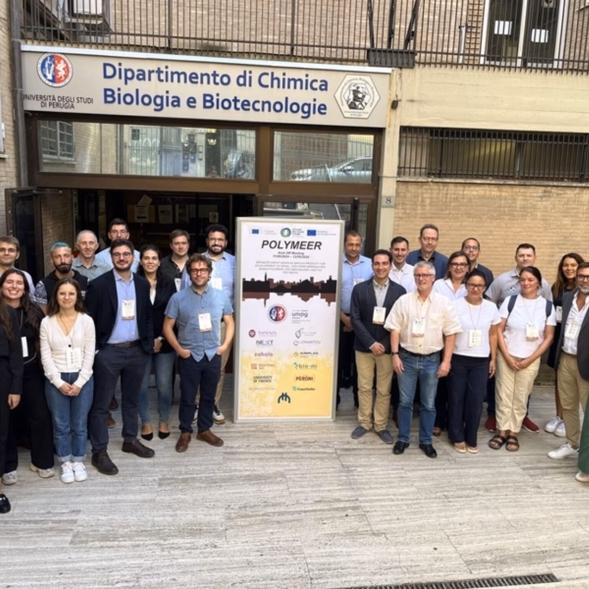 Participants pose for a group photo at an academic research or networking event venue.
