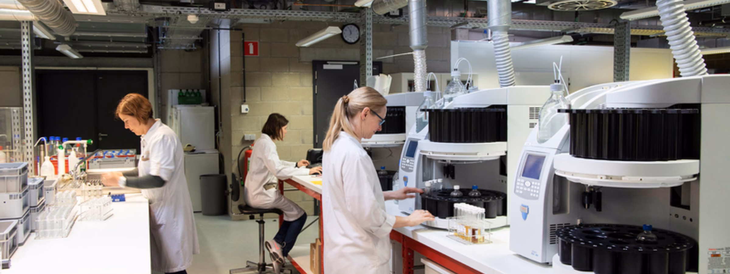 A modern laboratory equipped with automated analytical instruments and staff who perform laboratory tests.