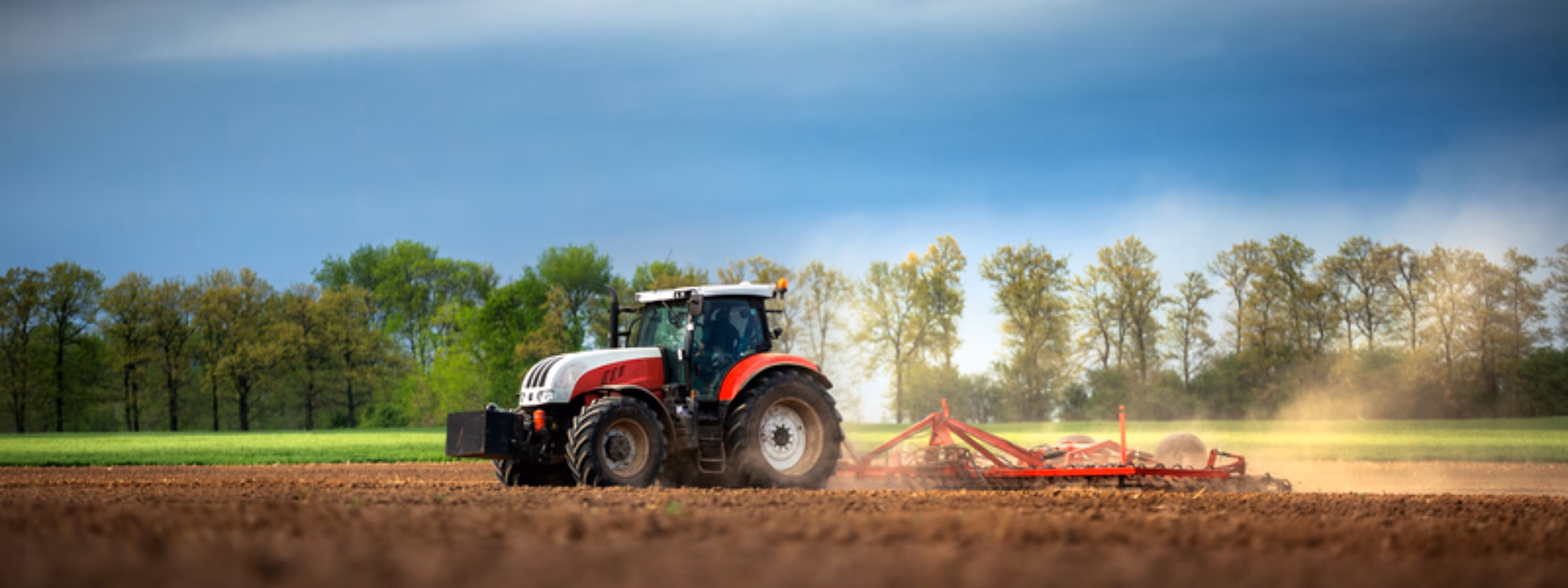 A tractor is tilling farmland in a field during outdoor fieldwork.