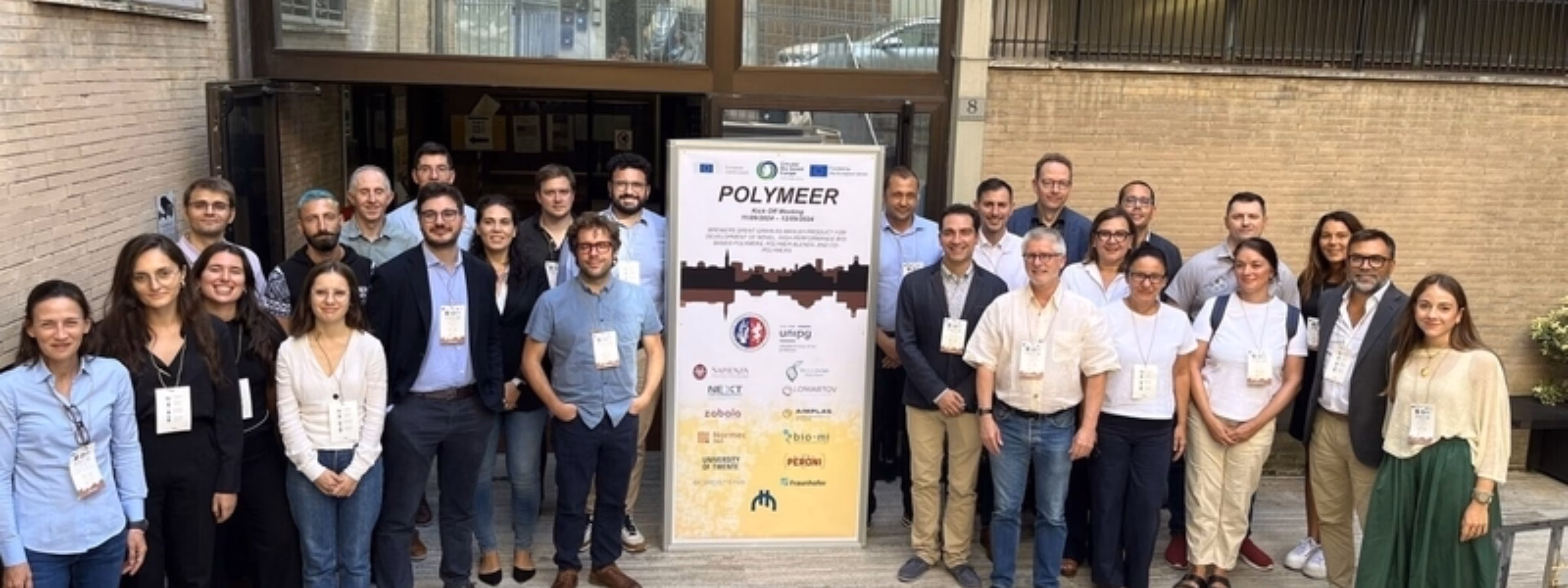 Participants pose for a group photo at an academic research or networking event venue.