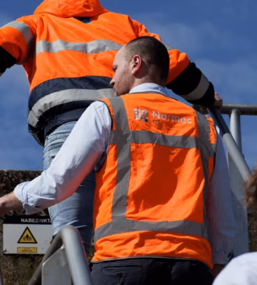 Medewerkers inspecteren een waterzuiveringsinstallatie tijdens een locatiebezoek.