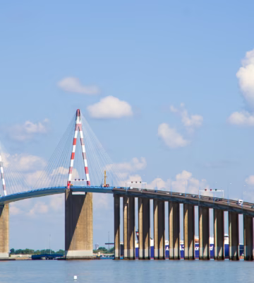 Een brug met tuien overspant een brede waterweg en vormt een belangrijke verkeersverbinding.