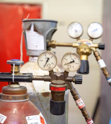 Gascilinders met aangesloten drukmeters en regelapparatuur voor gecontroleerde gasvoorziening.