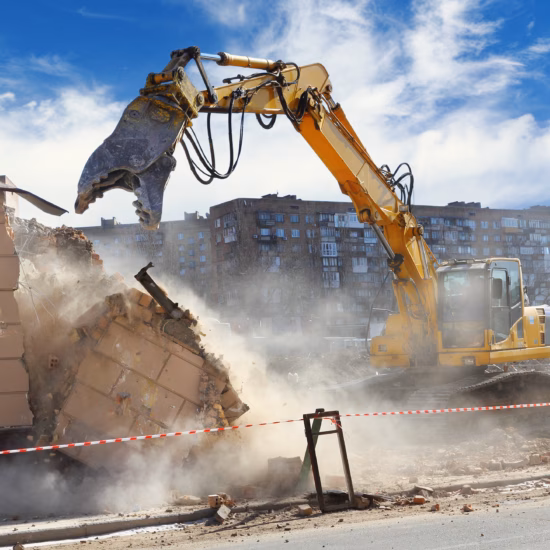 Bulldozer crushing the building at construction site